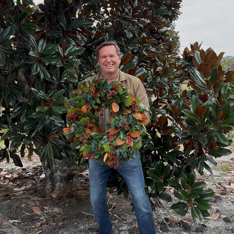 Matt holding Little Gem & Berries Wreath in Magnolia grove
